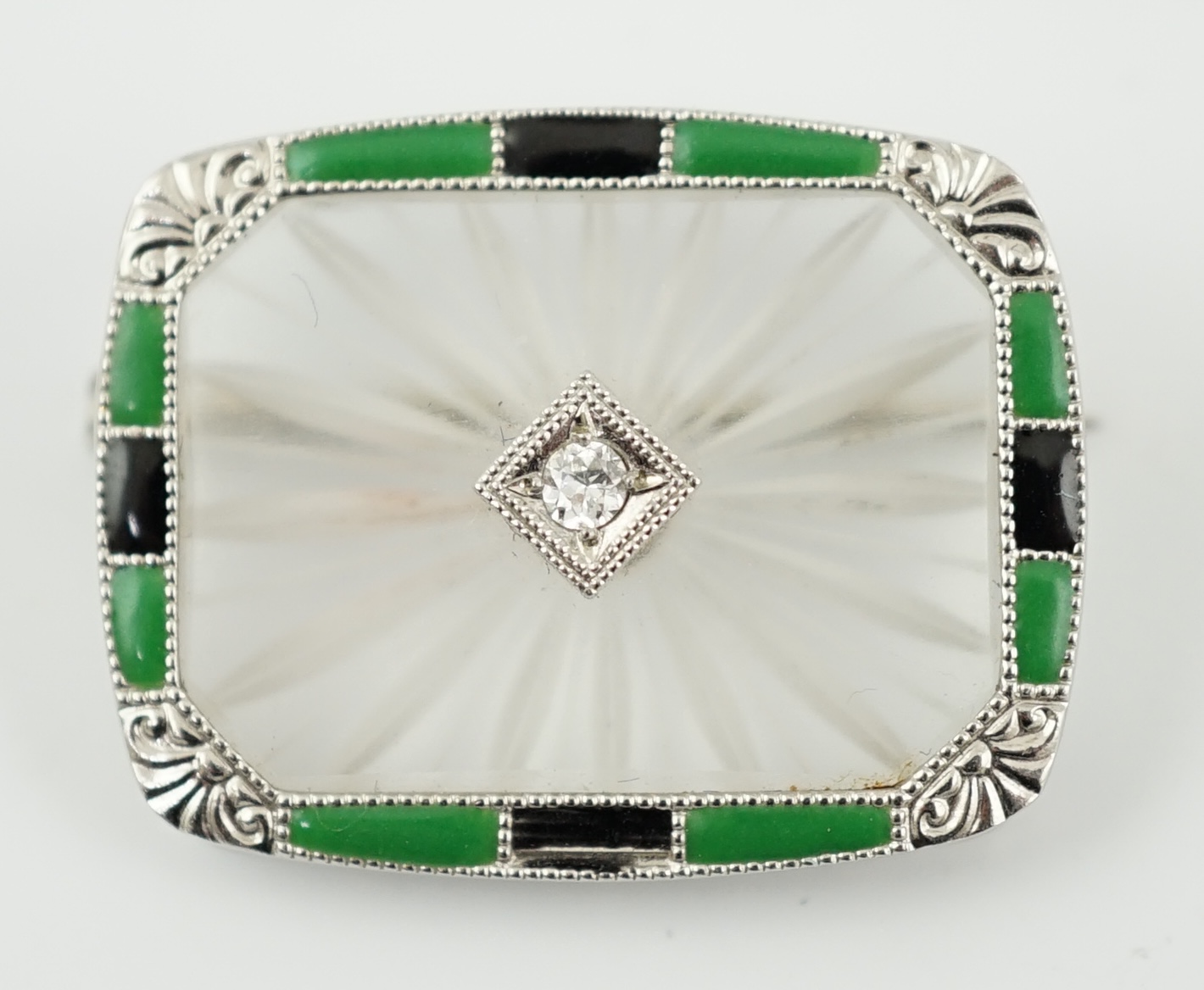 An Art Deco white gold, rock crystal, black onyx, chrysoprase and diamond set brooch